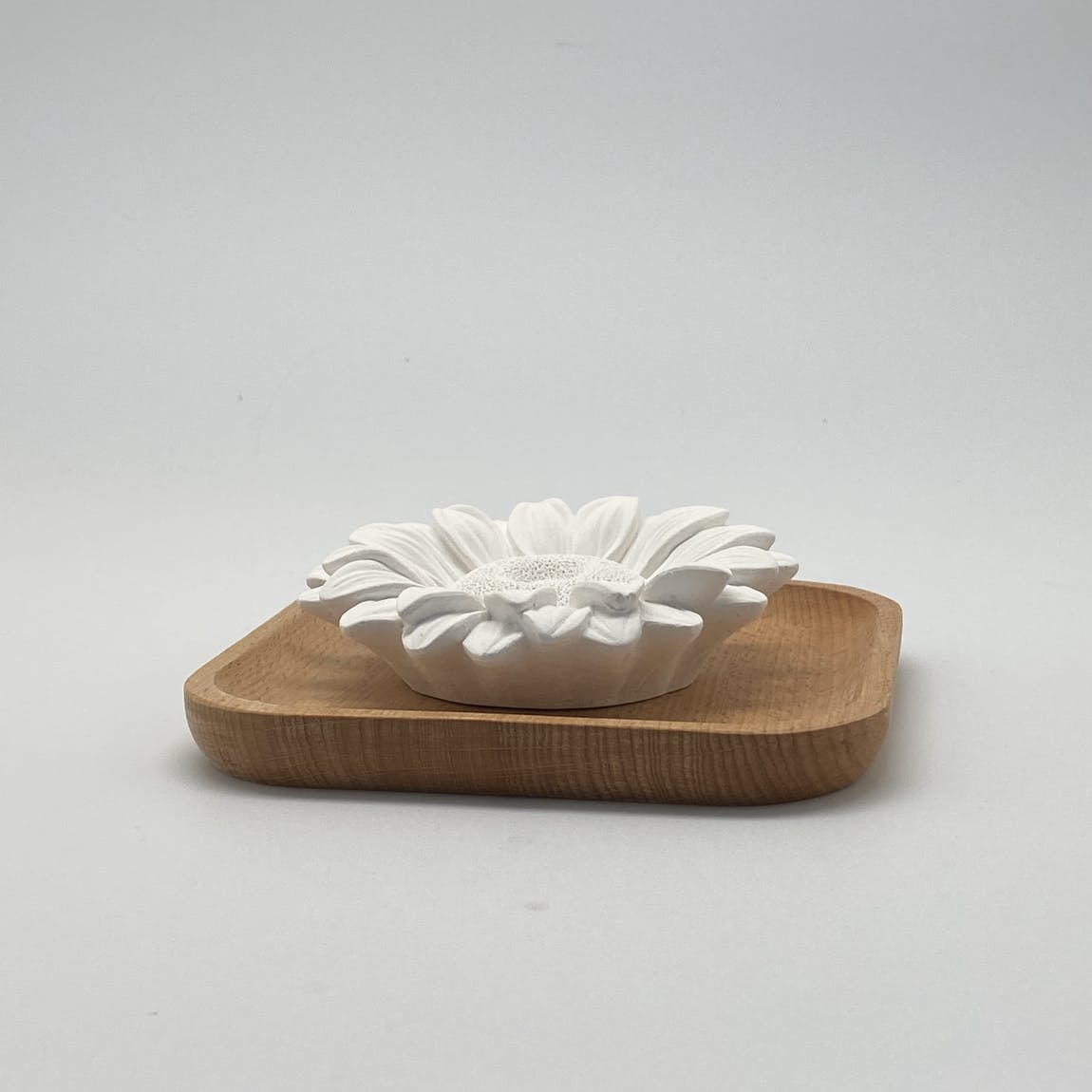 Difusor pasivo en forma de flor de yeso sobre base de madera.